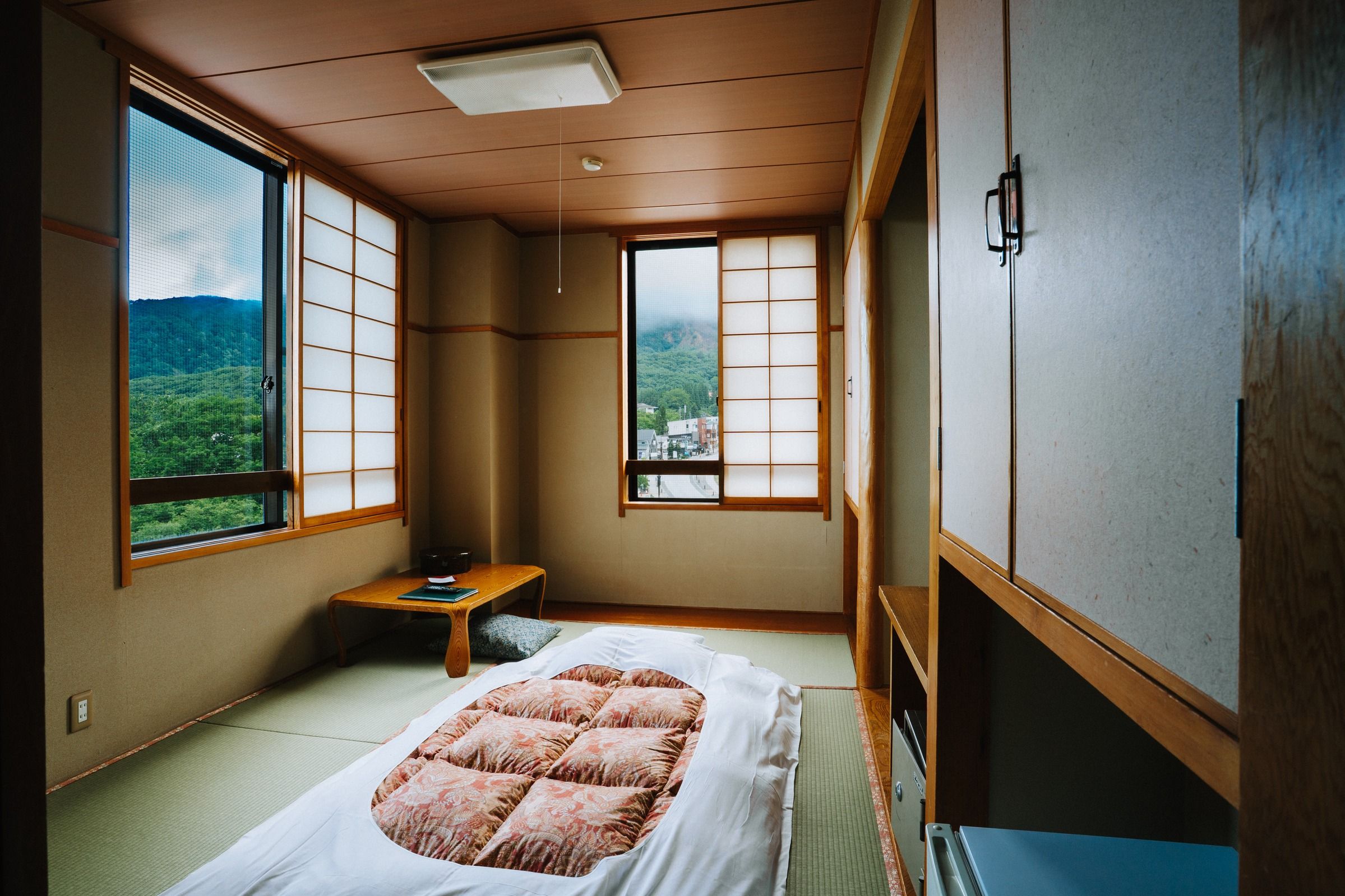 ひとり分の布団を敷いた、蔵王の眺めを楽しめるコンパクトな和室